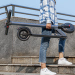 250W 15MPH 15Mi range electric scooter folded showing compact portability in urban environment
